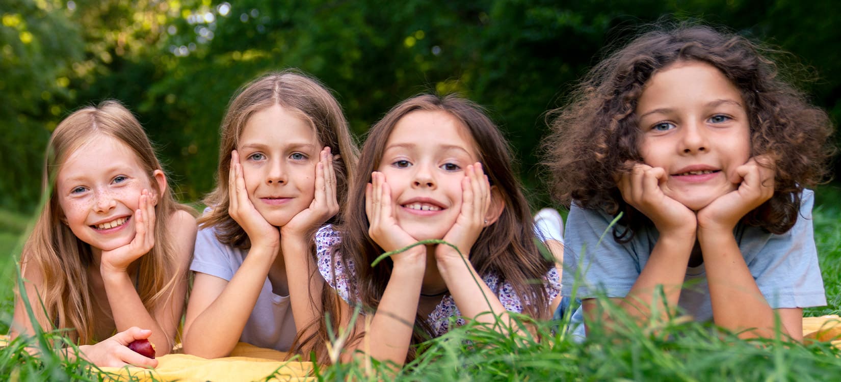 Glückliche Kinder liegen im Graß.