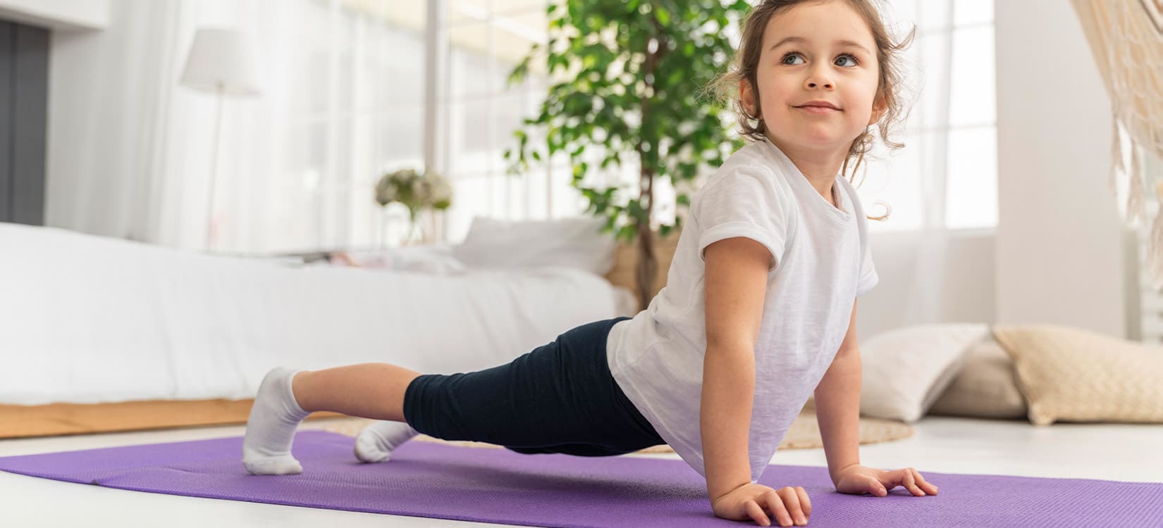 Kind macht Yoga auf Turnmatte.